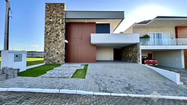 A fachada moderna de uma residência em Lajeado, Brasil, com jardim e área pavimentada.