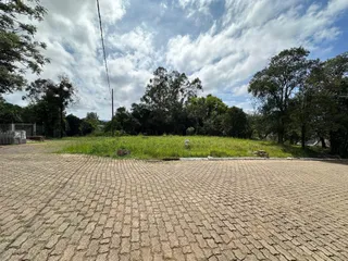 Área externa pavimentada com blocos de concreto em um terreno aberto.
