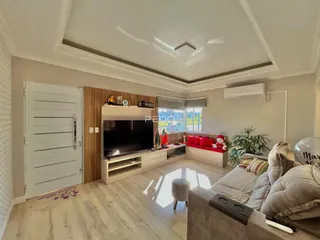 Sala de estar com piso de madeira clara e móveis modernos.