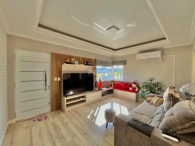 Sala de estar com piso de madeira clara e móveis modernos.