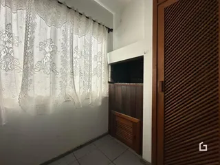 Vista interna de um corredor com paredes brancas e cortinas de renda.