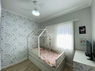Quarto com cama de madeira e papel de parede na sala.