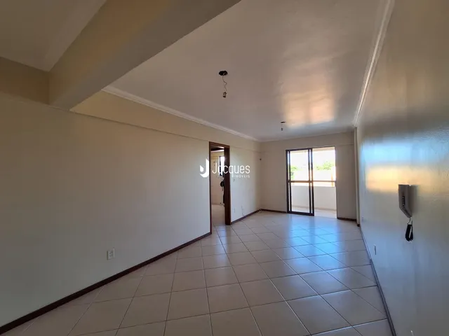 Hall de entrada com piso de cerâmica claro e paredes brancas.