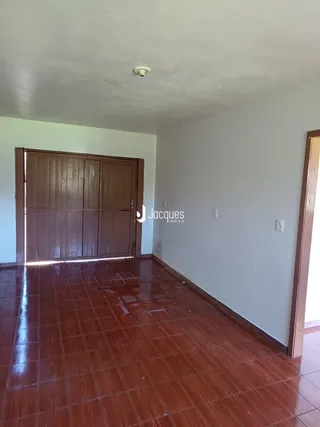 O piso da sala apresenta revestimento cerâmico marrom.