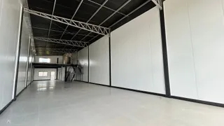 Corredor interno com piso claro e estrutura de teto exposta.