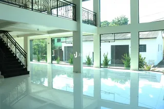 Vista interna de um espaço com grandes janelas e piso reflexivo.