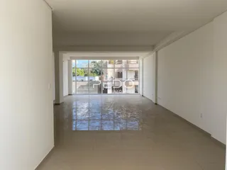 Corredor interno com paredes brancas e piso de cerâmica.