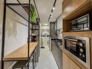 Vista de uma cozinha moderna com armários e piso claro.