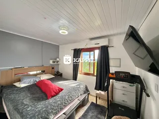 Um quarto com cama de casal e janela com cortinas escuras.