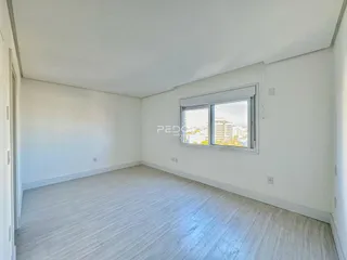 Ambiente interno de uma sala com paredes brancas e piso claro.