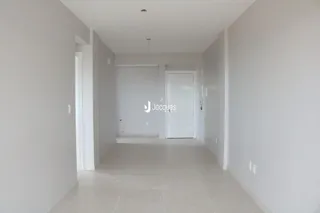 Corredor interno de uma residência com paredes brancas e piso claro.