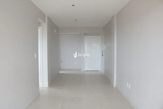 Corredor interno de uma residência com paredes brancas e piso claro.