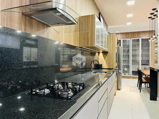 Cozinha moderna com armários de madeira e bancada escura.