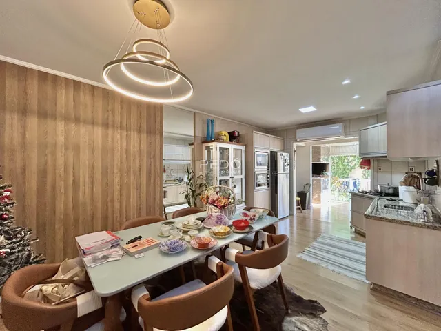 Sala de jantar com mesa de madeira e decoração moderna em imóvel no Brasil.