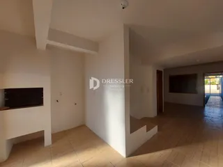 Hall de entrada com piso de cerâmica clara e paredes brancas.
