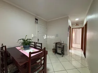 Vista de uma sala de jantar com mesa de madeira e plantas em um imóvel no Brasil.