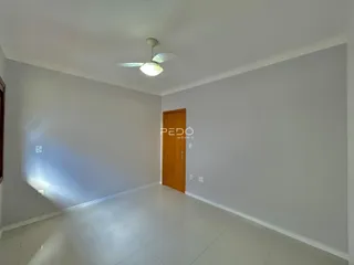 Vista interna de um corredor com paredes brancas e piso de cerâmica.