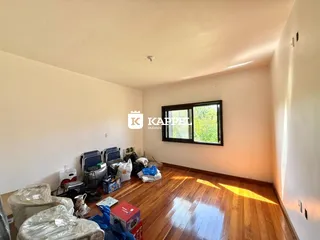 Sala de estar com piso de madeira e janela em um imóvel em Lajeado.