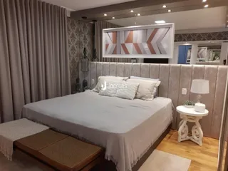 Quarto com cama grande e cabeceira estofada.