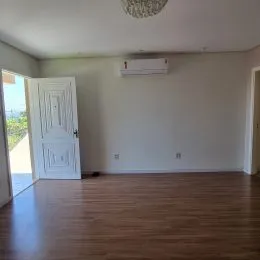 Foto de um cômodo interno com piso de madeira e ar-condicionado instalado.