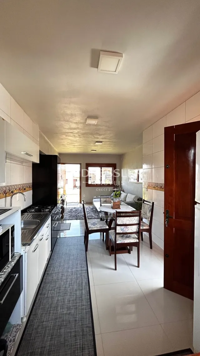 Interior de uma cozinha e sala de jantar com piso de cerâmica.