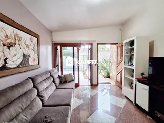 Sala de estar com sofá grande e piso de porcelanato.