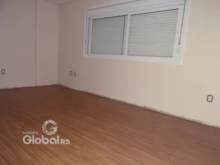 Quarto com piso de madeira e janela no interior de uma residência.