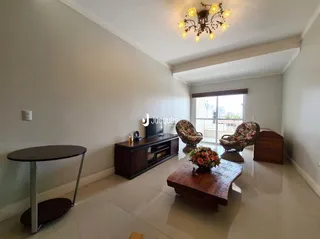 Uma sala de estar com móveis de madeira e paredes brancas.