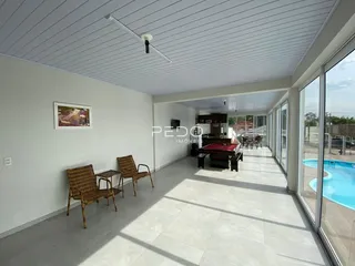 Sala de estar com piso claro e vista para o exterior.