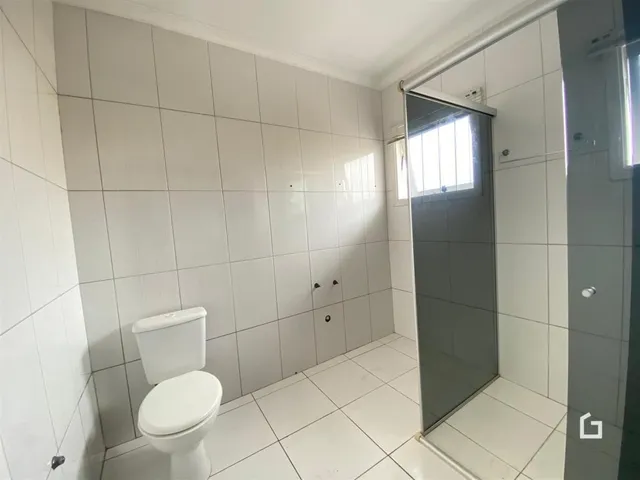 Foto de um banheiro com revestimento cerâmico branco.