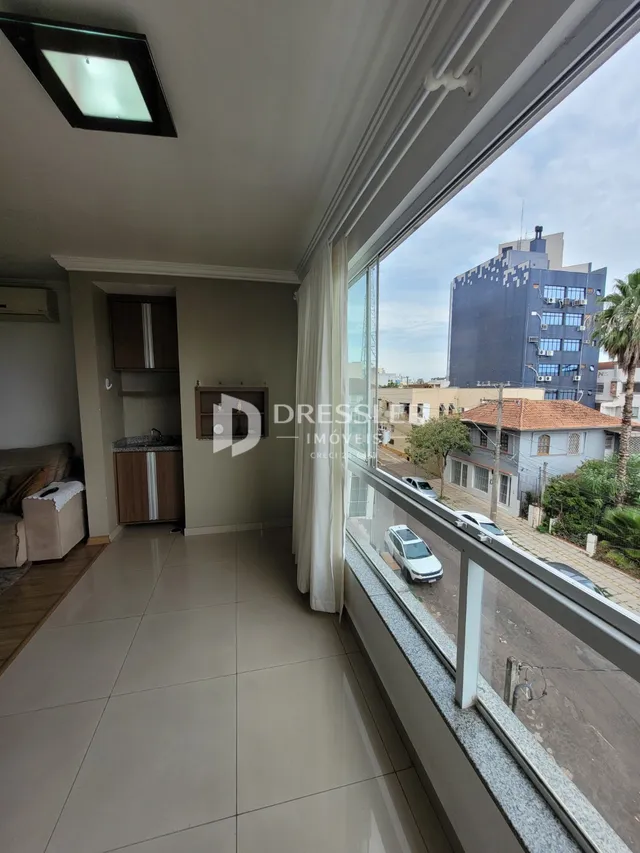 Vista de um corredor interno com vista para uma varanda.