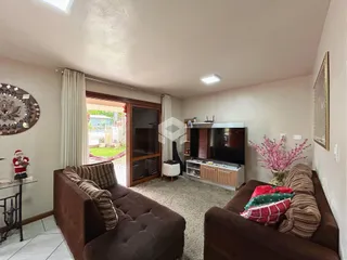 Sala de estar com sofá marrom e televisão em um imóvel no Brasil.