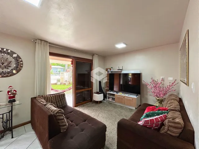 Sala de estar com sofá marrom e televisão em um imóvel no Brasil.
