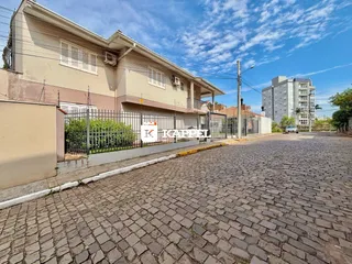 Fachada de uma residência em Lajeado, Brasil, com cerca e calçada de paralelepípedos.