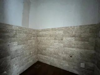 Parede revestida de pedra na área interna da propriedade.