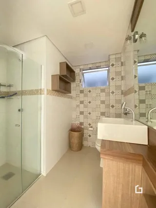 Hall com revestimento de azulejos e box de vidro na propriedade.
