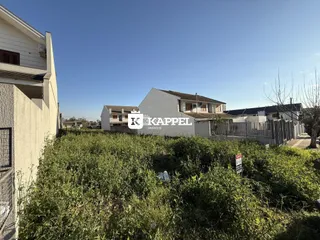 Vista externa de uma propriedade com vegetação densa no primeiro plano.