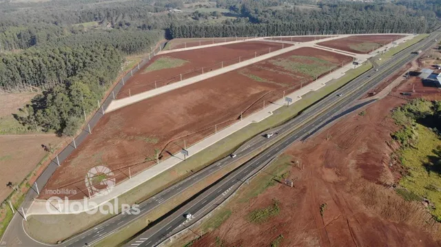 Vista aérea de um terreno aberto com áreas de vegetação e estradas.