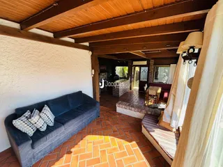 Sala de estar com piso de tijolos e vigas de madeira.