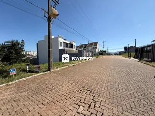 Fachada de casas residenciais em uma rua pavimentada em Lajeado.