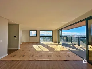 Sala de estar com piso de madeira e vista panorâmica da cidade.