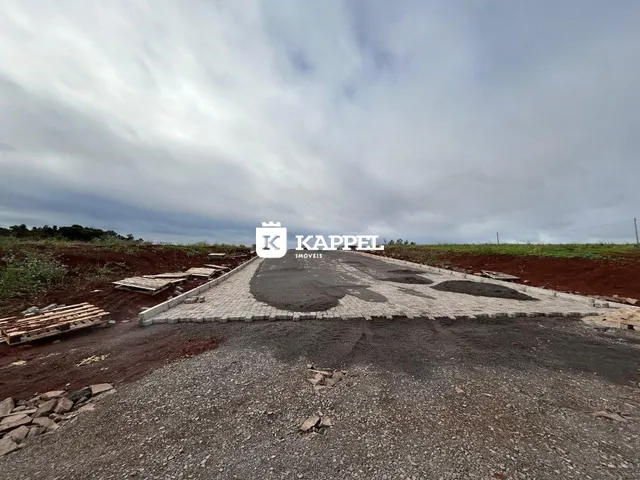 Vista externa de um terreno em desenvolvimento com acesso por estrada de terra.