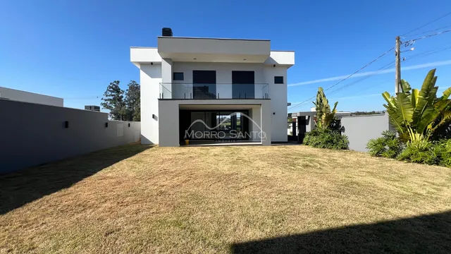 Fachada de uma casa moderna branca em Lajeado, Brasil, com jardim gramado.