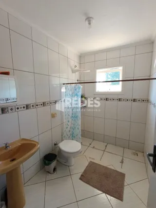 Foto de um banheiro com revestimento de azulejos brancos.