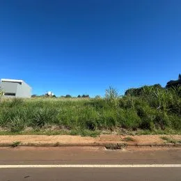 Vista de uma área de campo e estrada sob um céu azul claro.