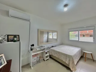 Quarto com cama e janela em ambiente claro.