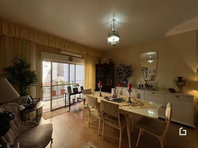 Ambiente interno de uma sala de jantar com piso de madeira e vista para o exterior.