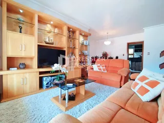 Sala de estar com móveis de madeira e um sofá laranja.