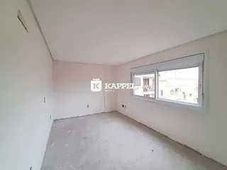 Foto de um cômodo vazio com piso de concreto e janela.