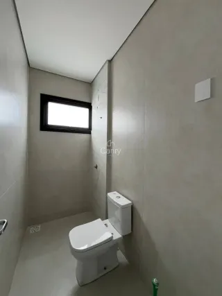 Foto de um banheiro simples com vaso sanitário branco e janela.